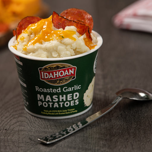 Idahoan® Roasted Garlic Mashed Potatoes Cup made on a table with cheese and pepperoni
